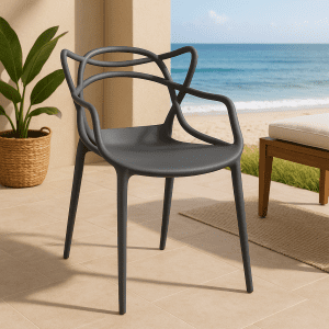 Grey bistro plastic chair with artistic backrest placed on a coastal patio overlooking the sea.