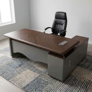 A premium 2 M Large Executive Desk featuring a thick brown textured wood top with rounded edges, a matte gray front modesty panel, and an attached side storage return credenza with two drawers and open shelves.