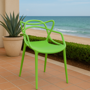 Green bistro plastic chair with artistic backrest placed in a tropical coastal café setting.