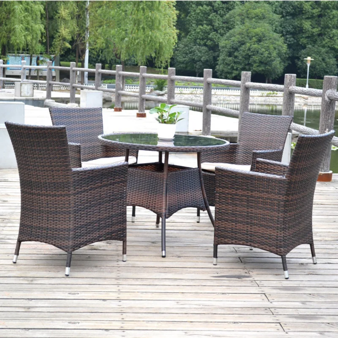 Outdoor Rattan Dining Set with round glass table and four patio chairs