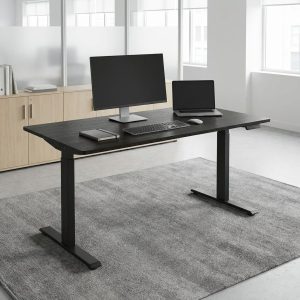 Electric height adjustable desk featuring a rectangular walnut wood tabletop, a digital control panel, and a heavy-duty black steel frame with T-legs.