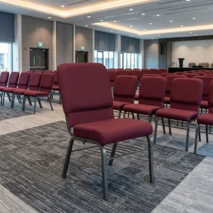 Modern Maroon Banquet Chair with maroon fabric upholstery, cushioned seat, high padded backrest, dark metal legs and horizontal frame supports.