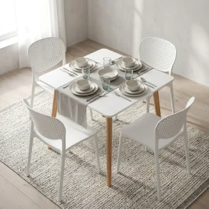 Dining Table And Chairs For 4 with white rectangular tabletop, four tapered wood-look legs and four white chairs with curved perforated backrests.