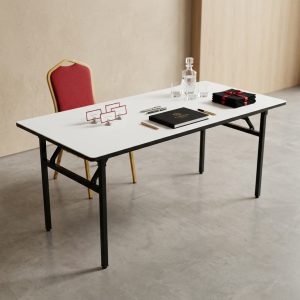 A White 6ft Folding Table featuring a seamless white rectangular tabletop and a sturdy black powder-coated steel folding frame.