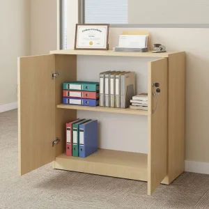 A premium low-profile Lockable Wooden Office Cabinet featuring a light oak wood grain finish, two outward-opening solid panel doors with curved brushed chrome handles, an integrated key lock on the right door, and an internal adjustable wooden storage shelf holding file binders and books.