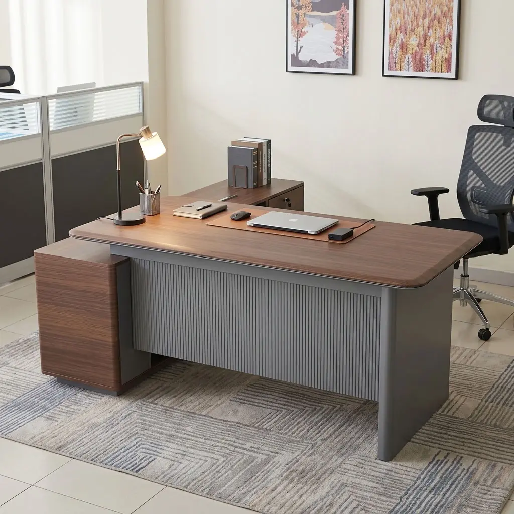 A premium L-shaped 1.6M Corporate CEO Office Desk featuring a thick teak-finished wooden top with curved corners, a prominent charcoal gray fluted front modesty panel, an integrated flip-up silver power grommet, and an attached side storage credenza with two storage drawers and open shelves.
