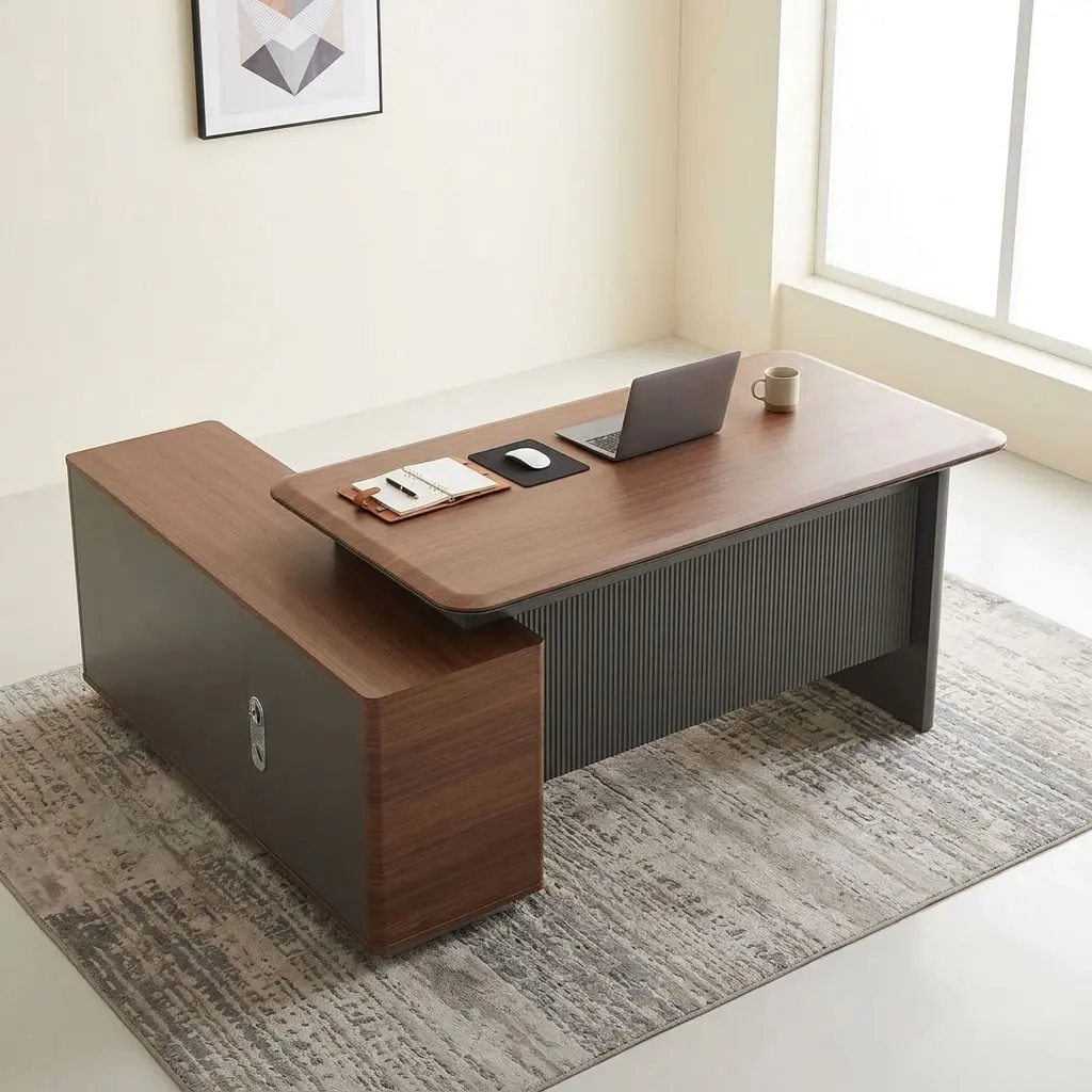 A premium L-shaped 1.6M Corporate CEO Office Desk featuring a thick teak-finished wooden top with curved corners, a prominent charcoal gray fluted front modesty panel, an integrated flip-up silver power grommet, and an attached side storage credenza with two storage drawers and open shelves.